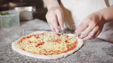 真正的意大利香肠比萨饼，烹饪方法，意大利厨师准备真正的意大利比萨饼，洒比萨饼奶酪。